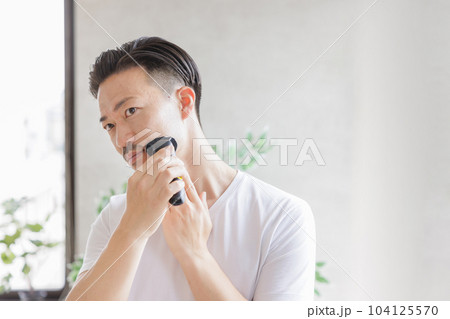 電気シェーバーで髭を剃る男性 104125570