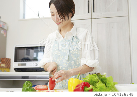 キッチンでトマトを切るミドルエイジ女性 104126549