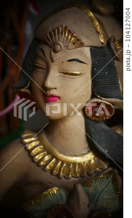 Beautiful artistic statue of a Balinese or javanese dancer used as garden decoration, javanese gnome indonesia 104127004