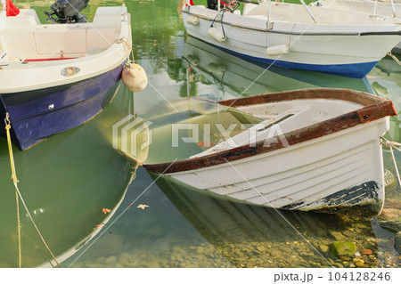 Fishing boats at the pier, sunken boat on the pier, selective focus, idea for background Fishing boats at the pier, sunken boat on the pier, selective focus, idea for background 104128246