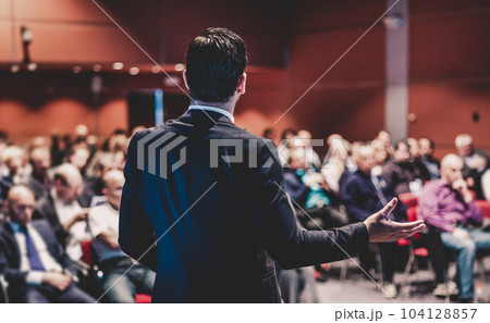Speaker at Business Conference with Public Presentations. Audience at the conference hall. Entrepreneurship club. Rear view. Panoramic composition. Background blur. Speaker at Business Conference with Public Presentations. Audience at the conference hall. Entrepreneurship club. Rear view. Panoramic composition. Background blur. 104128857