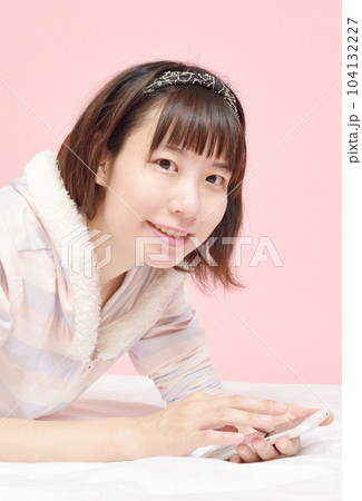 パジャマ姿でスマホを操作する女性 パジャマ姿でスマホを操作する女性 104132227