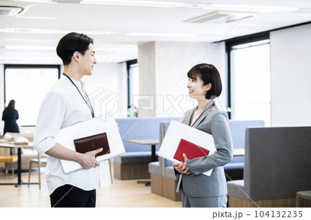 オフィスで会話する男女の会社員 オフィスで会話する男女の会社員 104132235
