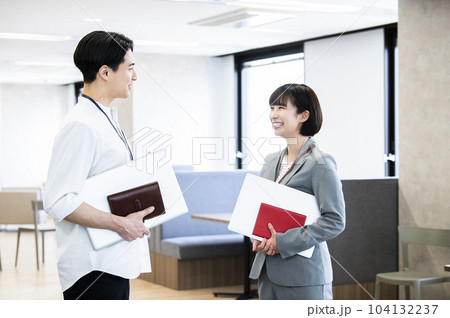 オフィスで会話する男女の会社員 104132237