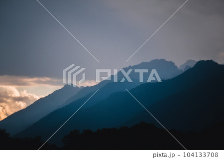 Dark clouds and rain over mountains in Dolomites, Italy 104133708