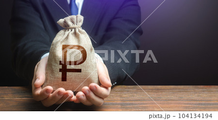 Businessman holds out russian ruble money bag. Getting a grant. Easy Money. Salary benefits. Attracting investments. Deposit savings. Cashback. Banking and crediting. Mortgage, loan approval. Businessman holds out russian ruble money bag. Getting a grant. Easy Money. Salary benefits. Attracting investments. Deposit savings. Cashback. Banking and crediting. Mortgage, loan approval. 104134194