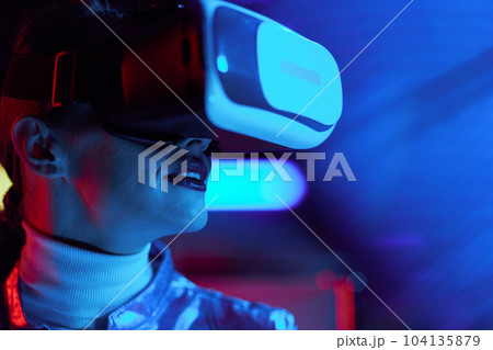 Portrait of trendy woman in vr headset on dark background 104135879