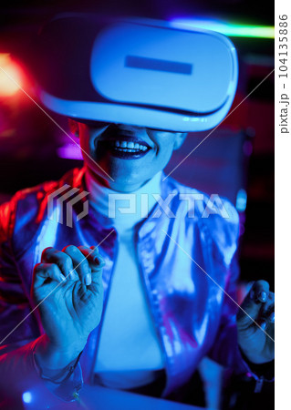 excited elegant woman in vr headset on dark background excited elegant woman in vr headset on dark background 104135886