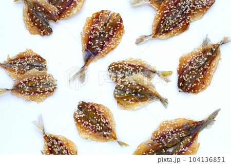 Dried fish with sesame seeds on white background. Dried fish with sesame seeds on white background. 104136851