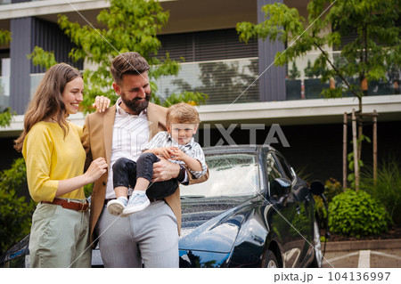 Happy family standing in front their car and charging electric car on the street. Happy family standing in front their car and charging electric car on the street. 104136997