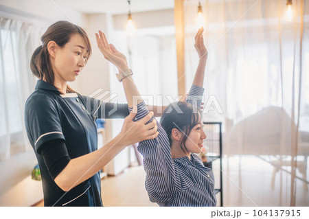 若い女性の身体の調子を見る女性整体師 104137915
