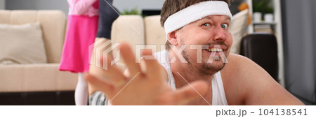 Laughing little girl pulling dad leg on floor 104138541