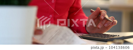 Woman makes calculations of checks on calculator closeup Woman makes calculations of checks on calculator closeup 104138606