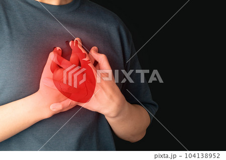 Man suffering from chest pain, having heart attack with heart organ anatomy over black background. Warning signs of unstable angina, myocardrial infarction, coronary artery disease. Cardiological. Man suffering from chest pain, having heart attack with heart organ anatomy over black background. Warning signs of unstable angina, myocardrial infarction, coronary artery disease. Cardiological. 104138952