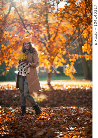 smiling stylish woman in beige coat and hat smiling stylish woman in beige coat and hat 104140317