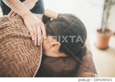 顔周りをマッサージされる若い女性 顔周りをマッサージされる若い女性 104140421