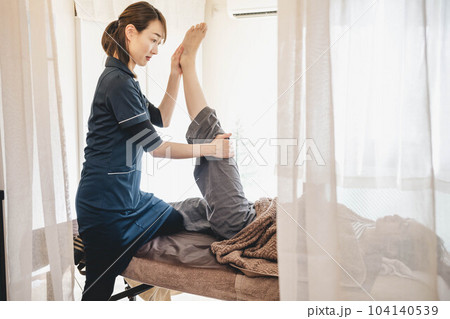 若い女性をマッサージする整体師 若い女性をマッサージする整体師 104140539