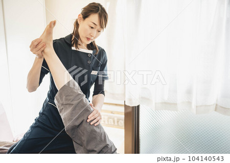 若い女性をマッサージする整体師 若い女性をマッサージする整体師 104140543