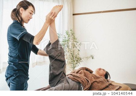 若い女性をマッサージする整体師 若い女性をマッサージする整体師 104140544