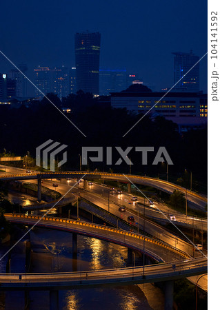 Night photo of a glowing multi-level road junction with heavy traffic. Roads in the metropolis 104141592