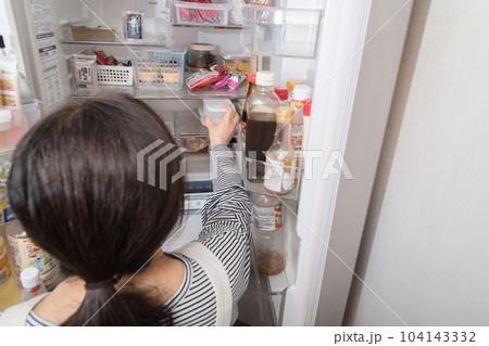 【冷蔵室からタッパを取り出す主婦】 104143332