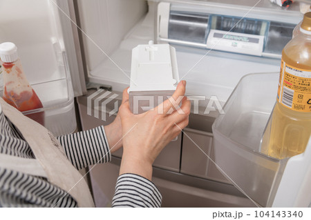 【冷蔵室から給水タンクを出す主婦】 【冷蔵室から給水タンクを出す主婦】 104143340
