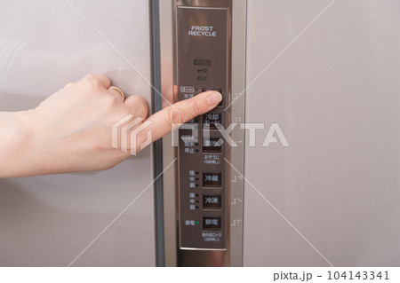 【冷蔵室の温度調整ボタンを押す主婦】 104143341