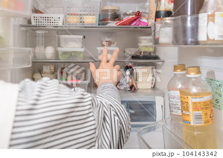 【冷蔵室からタッパを取り出す主婦】 104143342