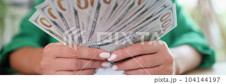 Business office desk woman counting money on hands analyzing income charts and graphs 104144197
