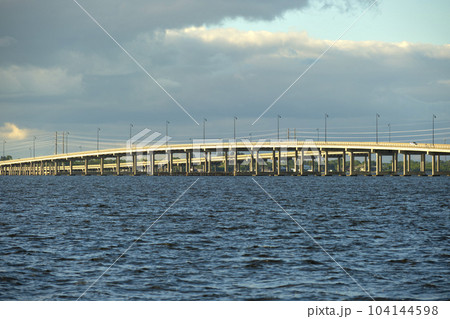 Barron Collier Bridge and Gilchrist Bridge in Florida with moving traffic. Transportation infrastructure in Charlotte County connecting Punta Gorda and Port Charlotte over Peace River Barron Collier Bridge and Gilchrist Bridge in Florida with moving traffic. Transportation infrastructure in Charlotte County connecting Punta Gorda and Port Charlotte over Peace River 104144598