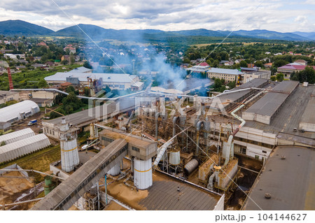Aerial view of wood processing plant with smokestack from production process polluting environment at factory manufacturing yard Aerial view of wood processing plant with smokestack from production process polluting environment at factory manufacturing yard 104144627