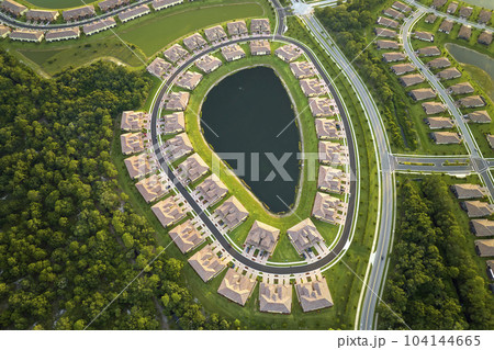 Aerial view of tightly located family houses with retention ponds to prevent flooding in Florida closed suburban area. Real estate development in american suburbs 104144665