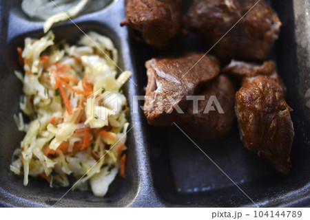 Meat appetizer with onions and cabbage. Barbecue with vegetables. Meat lunch. Meat appetizer with onions and cabbage. Barbecue with vegetables. Meat lunch. 104144789