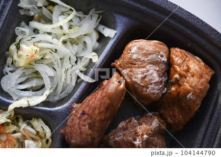 Meat appetizer with onions and cabbage. Barbecue with vegetables. Meat lunch. 104144790