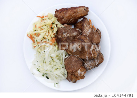 Beautiful fried pieces of pork meat. Pork kebab with vegetables. Meat on a plate. 104144791