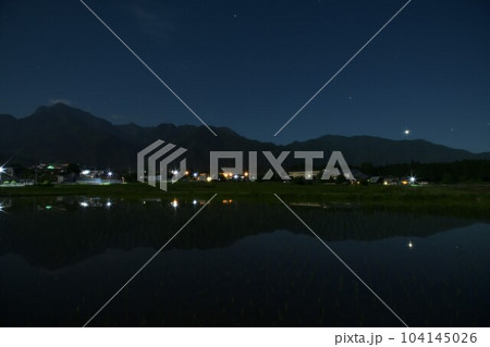 北杜市白州町、南アルプスの山際に降りた金星と火星を映す田植えの済んだ田んぼ 104145026
