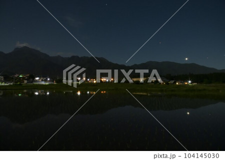 北杜市白州町、南アルプスの山際に降りた金星と火星を映す田植えの済んだ田んぼ 104145030