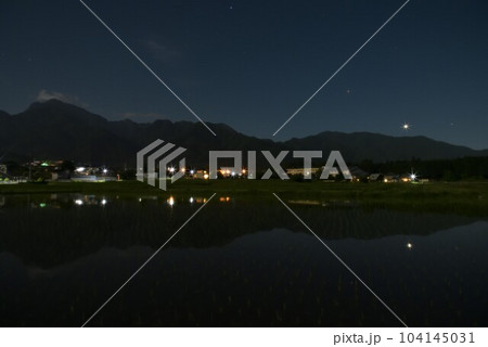 北杜市白州町、南アルプスの山際に降りた金星と火星を映す田植えの済んだ田んぼ 104145031