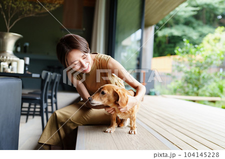 ダックスフンドを撫でる女性 104145228