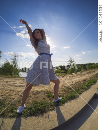 Young Dancer Posing in a Floral Summer Dress Young Dancer Posing in a Floral Summer Dress 104145556