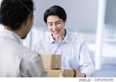 会社でダンボールや荷物を受け取るビジネスマン　配送や運送のイメージにも 104148190