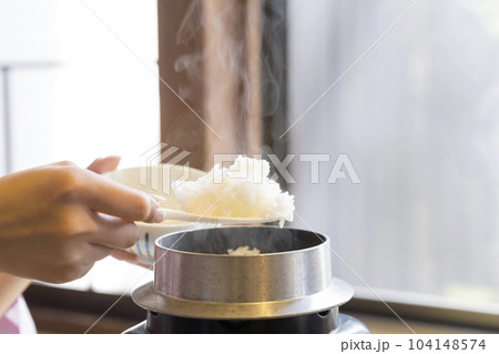 旅館朝食イメージ お釜で炊いた炊き立てご飯をよそる女性手元 旅館朝食イメージ お釜で炊いた炊き立てご飯をよそる女性手元 104148574