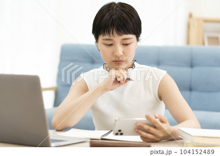 スマホを使い勉強をする若い女性 大学生 高校生 スマホを使い勉強をする若い女性 大学生 高校生 104152489