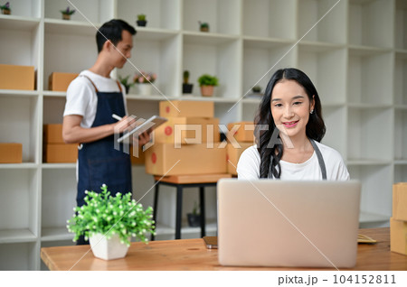 A female online shop owner is checking orders and updating new products on the website 104152811