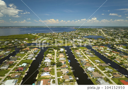 Aerial view of rural private houses in remote suburbs located on sea coast near Florida wildlife wetlands with green vegetation on gulf bay shore. Living close to nature in tropical region concept 104152950