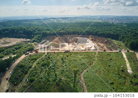 Aerial view of open pit mining of limestone materials for construction industry with excavators and dump trucks 104153018