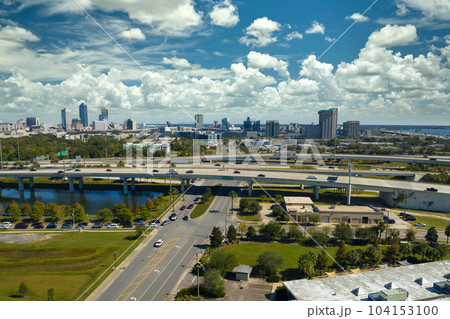 Aerial view of Jacksonville city with high office buildings and american freeway intersection with fast driving cars and trucks. View from above of USA transportation infrastructure Aerial view of Jacksonville city with high office buildings and american freeway intersection with fast driving cars and trucks. View from above of USA transportation infrastructure 104153100