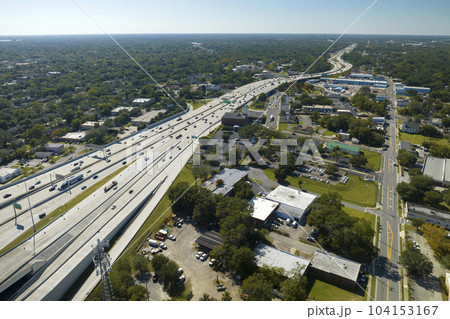 Aerial view of freeway overpass junction with fast moving traffic cars and trucks. Interstate transportation infrastructure in USA 104153167