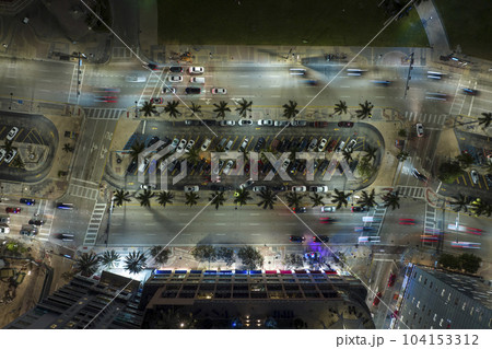 Aerial view of brightly illuminated street in downtown district of Miami city in Florida, USA. Traffic in modern american midtown 104153312
