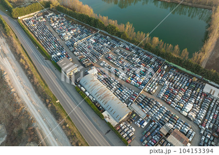 Aerial view of big parking lot of junkyard with rows of discarded broken cars. Recycling of old vehicles Aerial view of big parking lot of junkyard with rows of discarded broken cars. Recycling of old vehicles 104153394